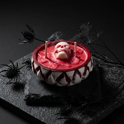 A Halloween-themed skull candle in a white and red bowl 